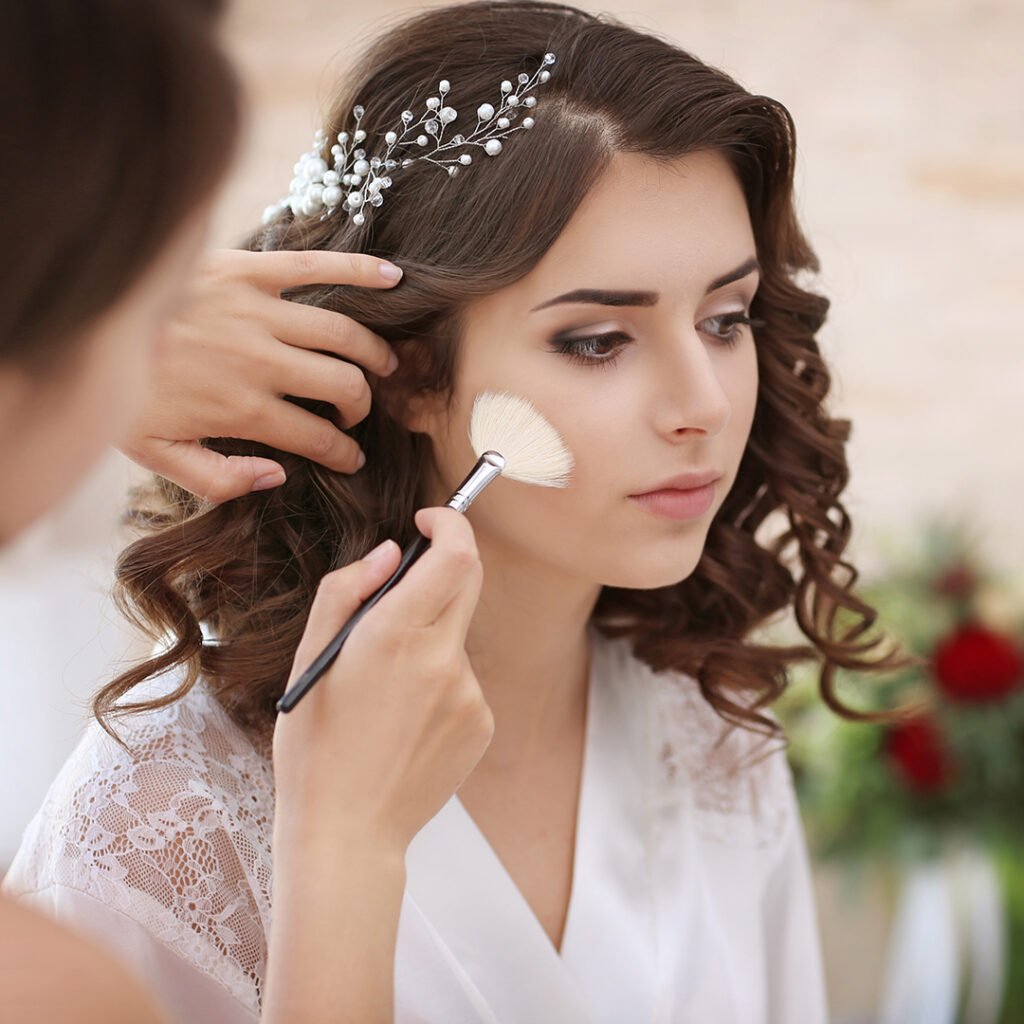 Makeup artist preparing bride before her wedding