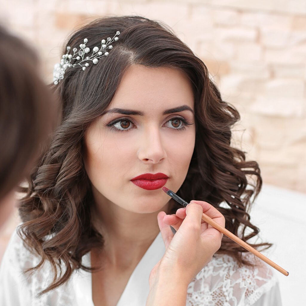 Makeup artist preparing bride before her wedding